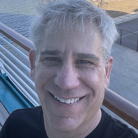 Adam, smiling in the sunshine on a ship deck